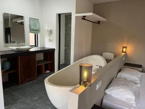 a bathroom with a bath tub and a sink at Angkor Sand Hotel in Siem Reap