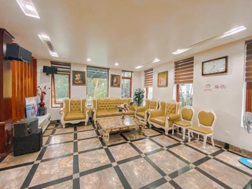a living room with yellow chairs and a couch at Flamigo Dai Lai Resort - Happy Villa in Ngọc Quang