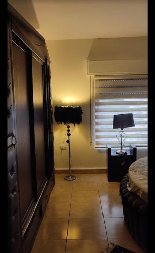 a bedroom with a bed and a lamp in a room at apartments furnished for rent in Amman Jordan in Amman