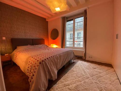 une chambre avec un lit et une grande fenêtre dans l'établissement Le Marais Cosy Central Paris, à Paris