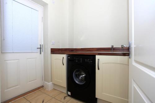 a laundry room with a washer and dryer at Beautiful 5 Bed Detached House - Sleeps 9 in Peterborough