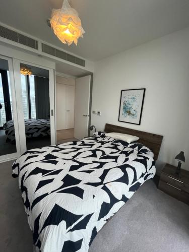 sypialnia z czarno-białym łóżkiem i żyrandolem w obiekcie 1 Bedroom Apartment Stratford w Londynie