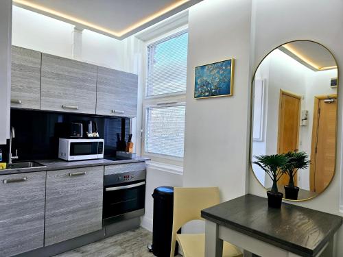 a kitchen with a table and a mirror at London Stay Apartments in London