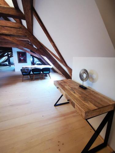an attic room with a wooden table and a lamp at Kníže Ferdinand Apartments in Mikulov