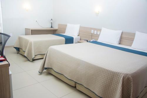 two beds in a hotel room with at Citi Executivo Hotel in Parnaíba