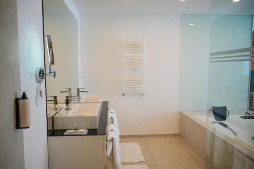 a white bathroom with a sink and a bath tub at ParkHotel by Vali Ranch Resort in Prilepnica