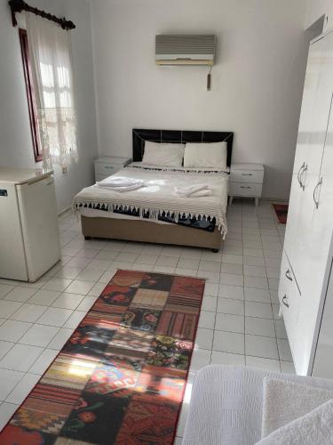 a bedroom with a bed and a rug on the floor at Sevgi Hotel Kalkan in Kalkan