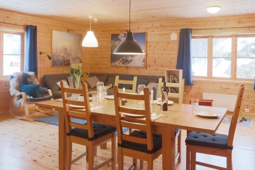 a dining room and living room with a table and chairs at Cabin Huskyfarm Innset in Innset