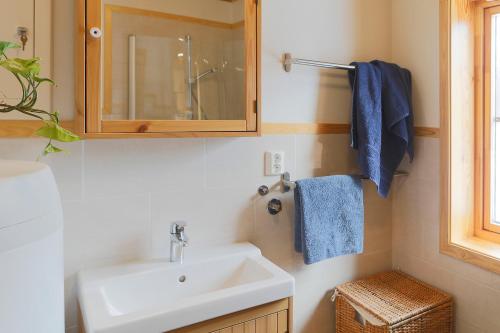 a bathroom with a sink and a mirror and blue towels at Cabin Huskyfarm Innset in Innset