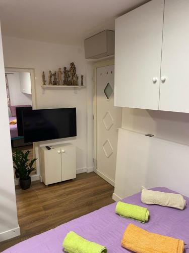 a living room with a purple bed with two towels at Studio Apartment in Split in Split