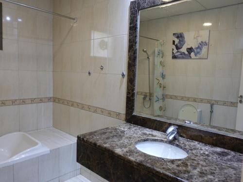 uma casa de banho com um lavatório, um espelho e um chuveiro em Beautiful Cool Room for Coupls & faimly em Dubai