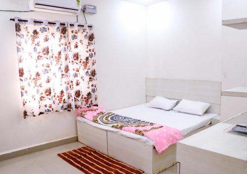Habitación pequeña con cama y cortina en ROYAL PALACE BY RAJASTHAN MAHESHWARI BHAWAN, en Katni