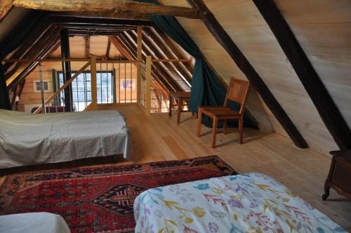 CoubisouにあるGîte Le Couderc de Coubisou, grange rénovéeの屋根裏部屋(ベッド2台、椅子付)