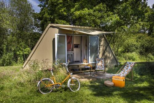 Thoissey的住宿－Camping De Thoissey ***，停在小帐篷前的自行车