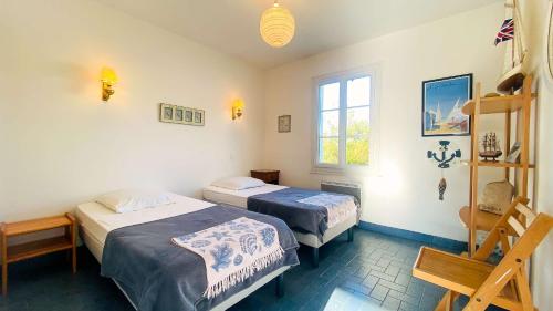 um quarto com 2 camas e uma janela em A proximité de la plage et du centre village, villa tout confort em Le Bois-Plage-en-Ré