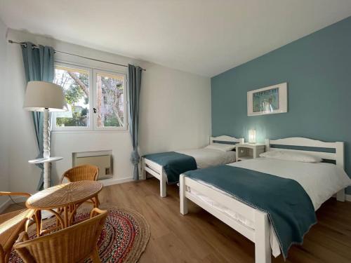 a bedroom with two beds and a table and chairs at Villa de Charme au coeur du Cap-Ferrat in Saint-Jean-Cap-Ferrat
