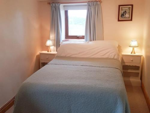 a bedroom with a bed with a window and two lamps at Fell View Bassenthwaite in Bassenthwaite