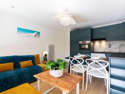 un salon avec un canapé bleu et une table dans l'établissement Appartement calme avec jardin/terrasse, à 5 min du centre, 6 pers, parking privé, navette gratuite. - FR-1-296-159, à Saint-Lary-Soulan