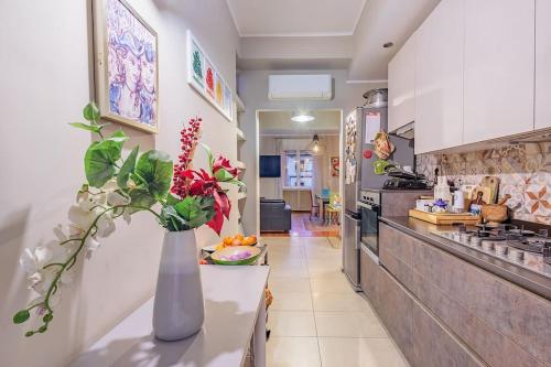 a kitchen with a vase of flowers on a counter at Stylish and Perfect Place for Families and Friends in Milan