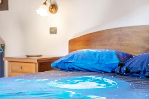 a bed with two blue pillows on top of it at Appartamento nel borgo di Chatillon in Châtillon
