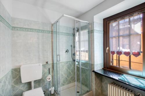 a bathroom with a shower and a toilet and a window at Appartamento nel borgo di Chatillon in Châtillon