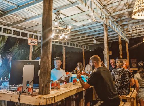 a group of people standing around a bar at Funky Moon Kampot in Kampot