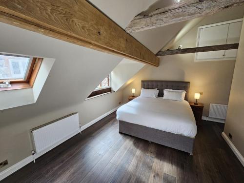 a bedroom with a white bed and two windows at Catton Old Hall Norwich in Norwich