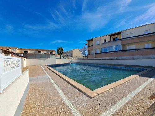 une piscine devant un immeuble dans l'établissement Maison mitoyenne climatisée avec terrasse et piscine à Marseillan - FR-1-326-474, à Marseillan