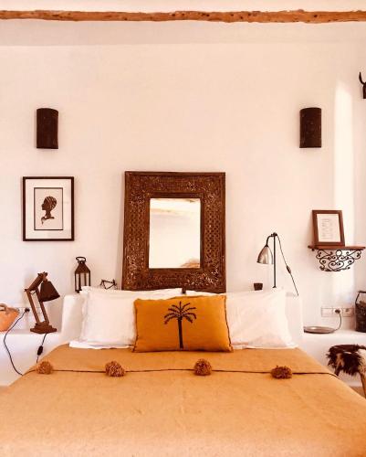 a bedroom with a bed with a mirror on the wall at Dar Alya Essaouira Maison et table d'hôtes in Ghazoua