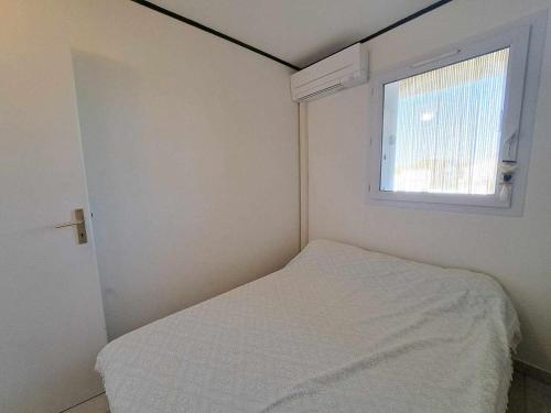 niewielka sypialnia z łóżkiem i oknem w obiekcie Appartement Marseillan-Plage, 2 pièces, 4 personnes - FR-1-326-707 w mieście Marseillan