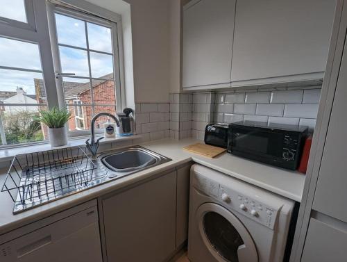 a kitchen with a sink and a washing machine at Shakespeare's Stay in Stratford-upon-Avon