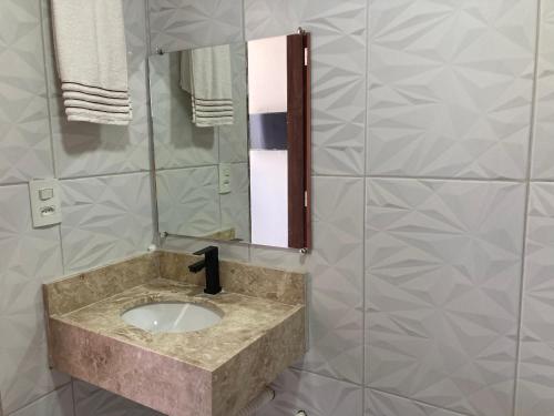 a bathroom with a sink and a mirror at Pousada Bella Flor in Baía Formosa