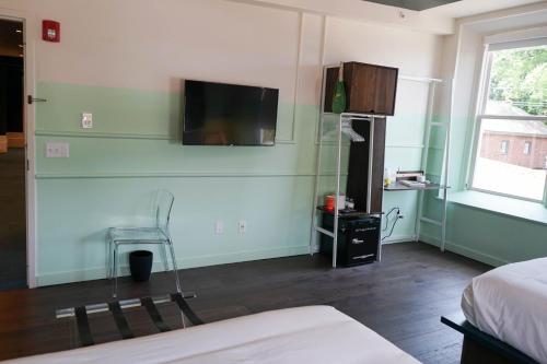 1 dormitorio con TV en la pared y 1 cama en The Russell en Nashville