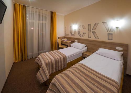 a hotel room with two beds and a desk at Raziotel Kyiv (Boryspilska) in Kyiv