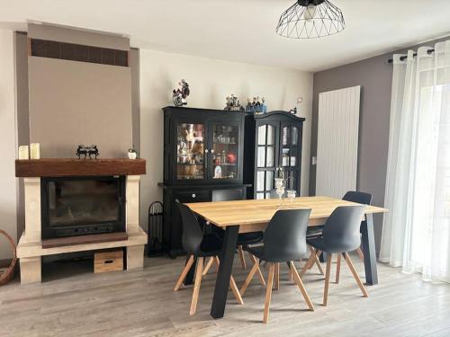 une salle à manger avec une table et une cheminée dans l'établissement Maison aux Portes de Paris, à Vitry-sur-Seine