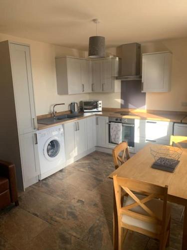 a kitchen with a table and a washing machine at Ivy House in Longnor