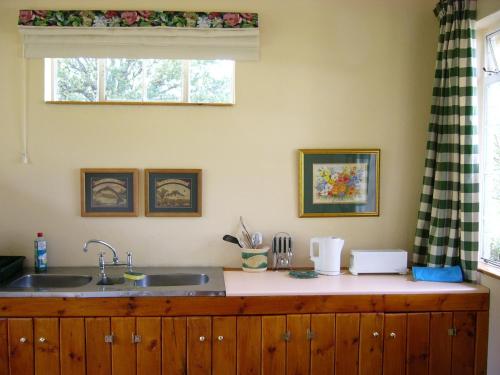 um balcão de cozinha com um lavatório e uma janela em Mkomazana Mountain Cottages em Himeville