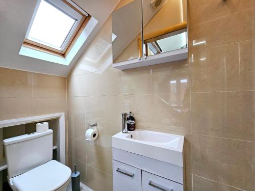 a bathroom with a toilet and a sink and a window at London Stay Apartments in London
