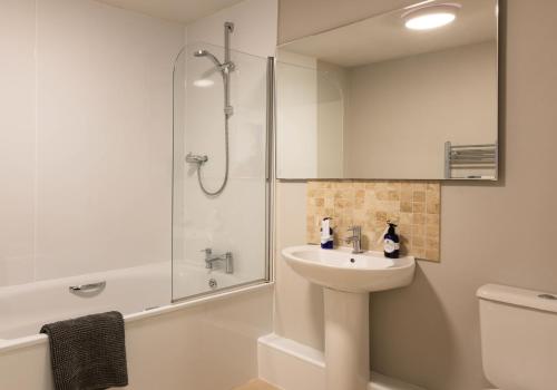 a white bathroom with a sink and a shower at 1 North Street, Elie in Elie