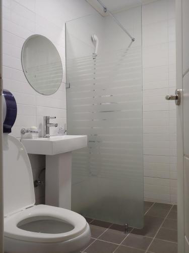 a bathroom with a shower and a toilet and a sink at Ekonomy Hotel in Gumi