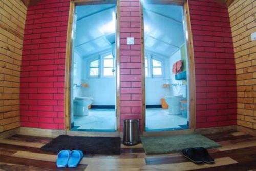 baño con 2 espejos y 2 chanclas azules en Kalawati Homes, en Shimla