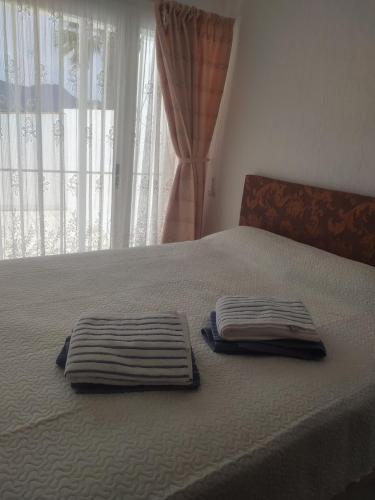 two towels sitting on top of a bed with a window at PARAÍSO in San Juan de los Terreros