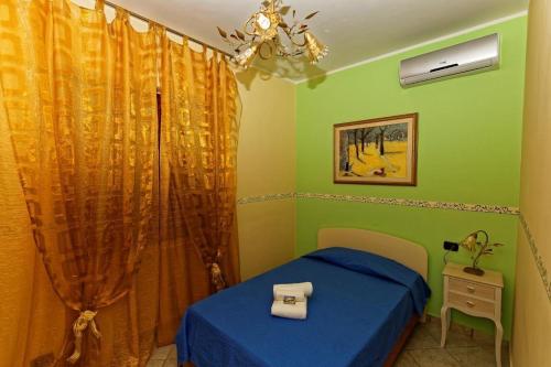 a bedroom with a blue bed and green walls at Bed & Breakfast La Villetta in Botricello