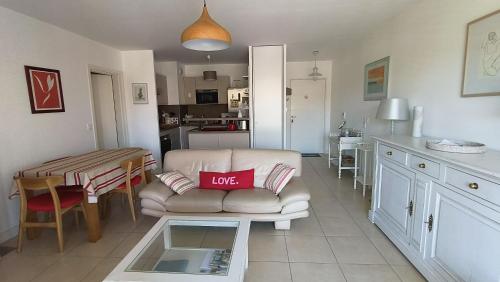 un salon avec un canapé et une table dans l'établissement Le Magellan Appartement Terrasse 4 personnes plage et centre ville, à Andernos-les-Bains