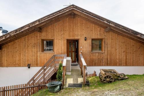 a wooden house with a staircase leading to the door at Malsötscherhof Apt C in Villandro