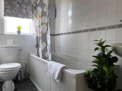 a bathroom with a tub and a toilet and a sink at Station House - 2bed House Central Location in Lincolnshire