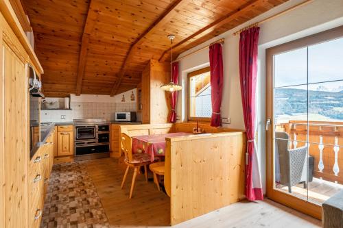 a kitchen with a table and a dining room at Malsötscherhof Apt C in Villandro