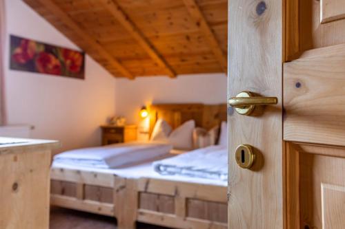 a bedroom with a bed and a wooden door at Malsötscherhof Apt C in Villandro