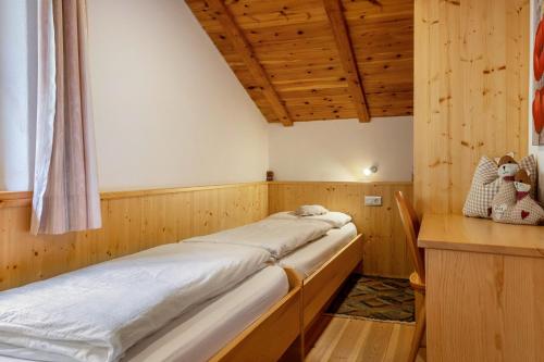 a room with two beds in a wooden room at Malsötscherhof Apt C in Villandro