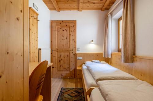 a room with two beds and a window at Malsötscherhof Apt C in Villandro